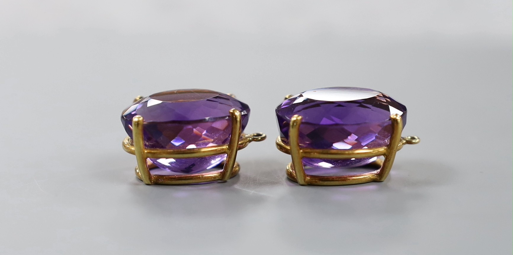 A modern pair of yellow metal mounted oval cut amethyst pendants?, 21mm, gross weight 13.8 grams.